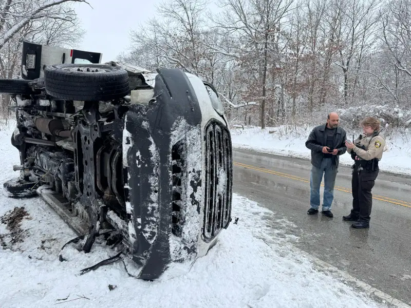A&N Towing operator coordinating with law enforcement at a winter accident recovery scene near Justice IL