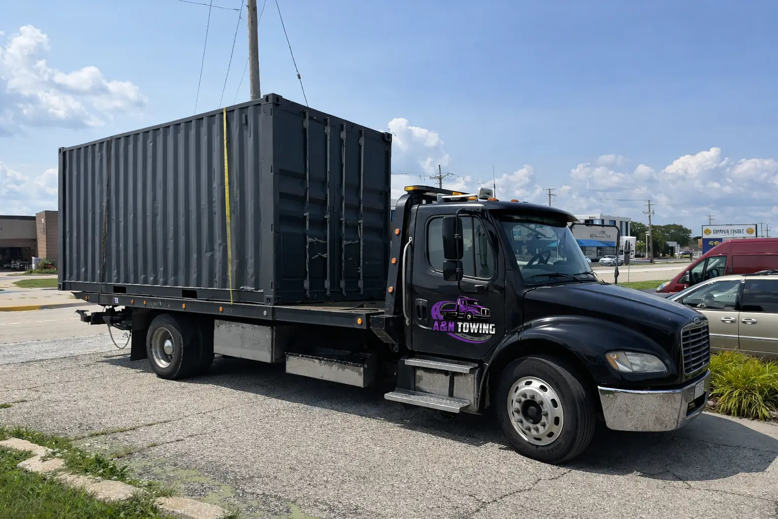 A&N Towing flatbed truck hauling a large shipping container for commercial transport in Chicago